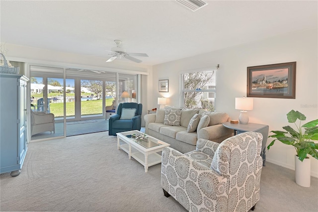 living area featuring visible vents, carpet, and ceiling fan