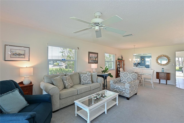 living room with visible vents, light colored carpet, a textured ceiling, and ceiling fan