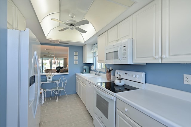 kitchen with white appliances, a ceiling fan, light tile patterned flooring, a sink, and white cabinets