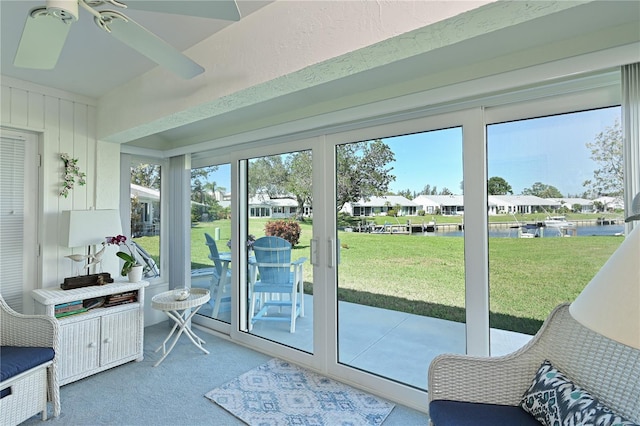 doorway to outside with carpet, ceiling fan, and a textured wall