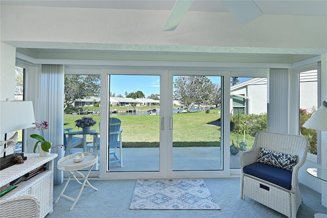 doorway to outside with light colored carpet, a healthy amount of sunlight, and ceiling fan