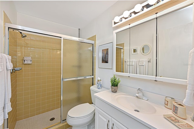 bathroom featuring vanity, toilet, and a stall shower