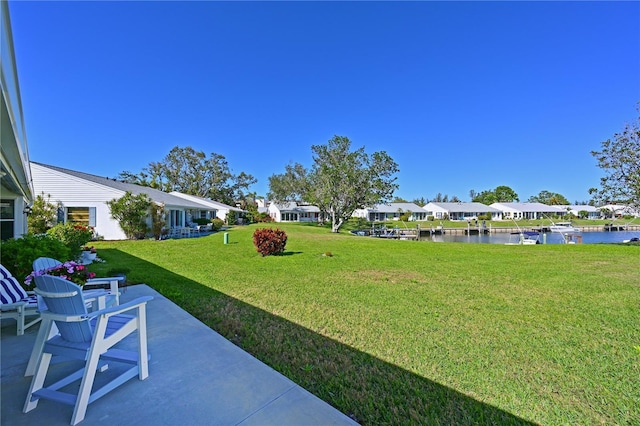 view of yard featuring a residential view, a patio, and a water view