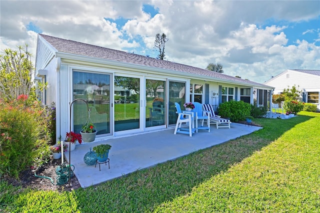 rear view of property featuring a patio and a lawn