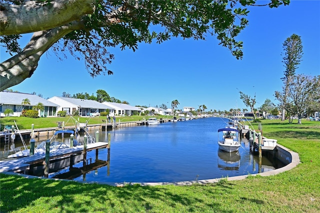 dock area with a lawn, a water view, and a residential view