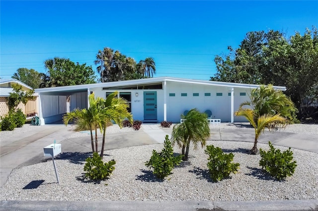 mid-century modern home with a carport and driveway