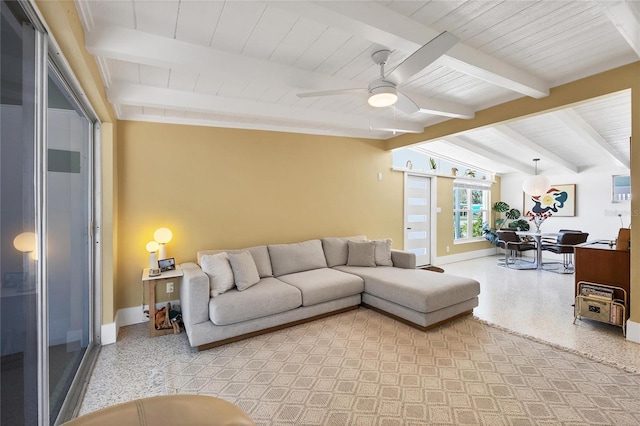 living area featuring light speckled floor, lofted ceiling with beams, baseboards, and a ceiling fan