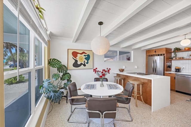 dining space with beam ceiling and light speckled floor