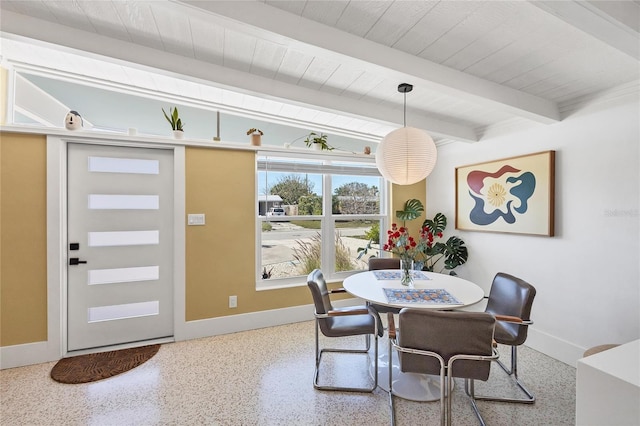 dining area with speckled floor, beam ceiling, and baseboards