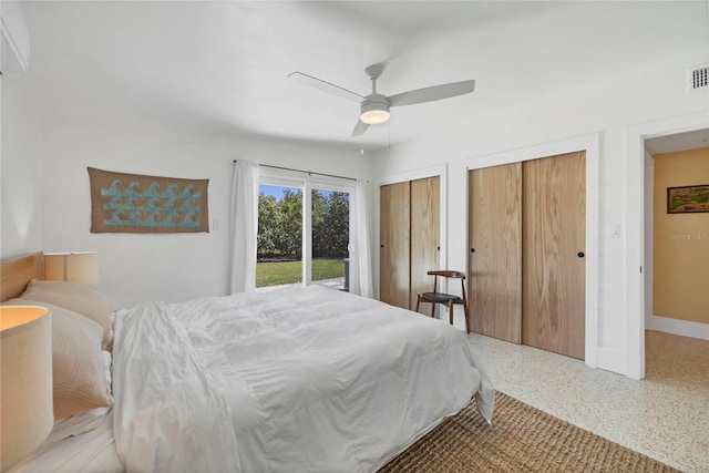 bedroom featuring visible vents, multiple closets, speckled floor, baseboards, and ceiling fan