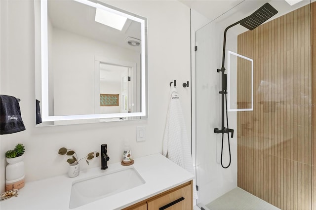 bathroom with a stall shower, a skylight, and vanity