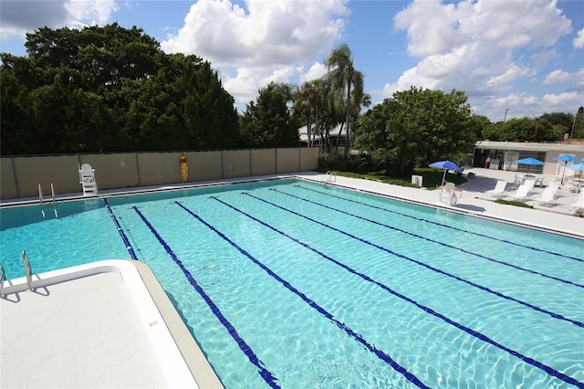 community pool featuring fence and a patio