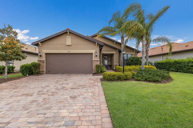 view of front of home with a front yard, stucco siding, decorative driveway, stone siding, and an attached garage