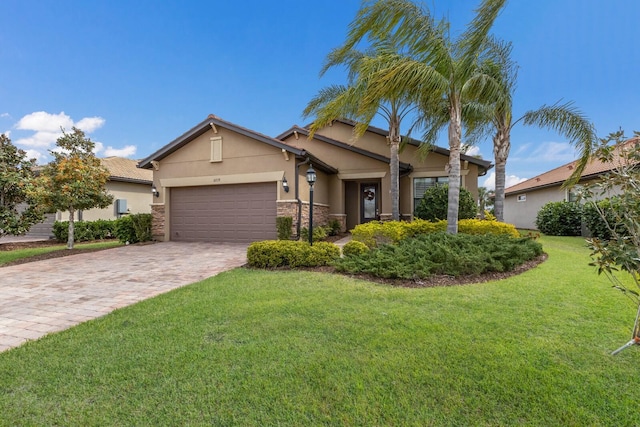 craftsman house with a front yard, decorative driveway, a garage, and stucco siding