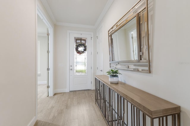 entryway featuring baseboards, ornamental molding, and light wood finished floors