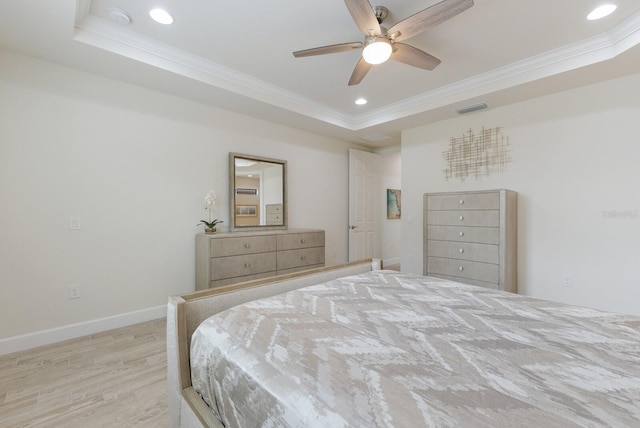 bedroom with recessed lighting, light wood-style flooring, a raised ceiling, and ornamental molding