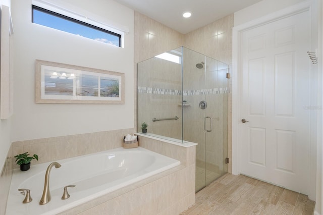 bathroom with a shower stall, a bath, wood finished floors, and recessed lighting