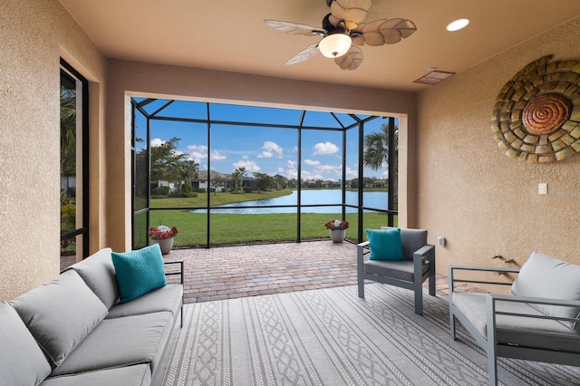 sunroom featuring visible vents, a water view, and ceiling fan