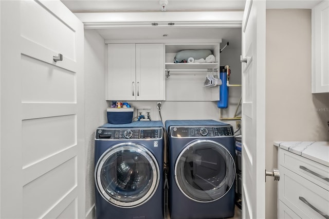 clothes washing area with cabinet space and separate washer and dryer