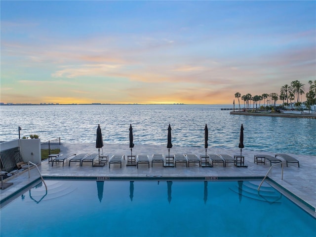 view of pool with central air condition unit and a water view