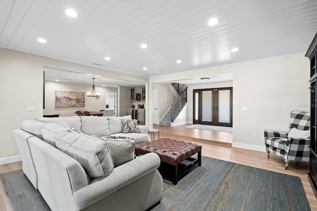 living room with wood finished floors, recessed lighting, french doors, stairway, and baseboards