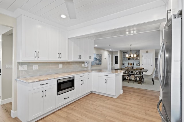 kitchen with an inviting chandelier, white cabinets, and stainless steel appliances