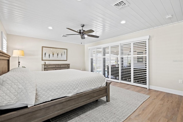 bedroom with access to exterior, visible vents, baseboards, and wood finished floors