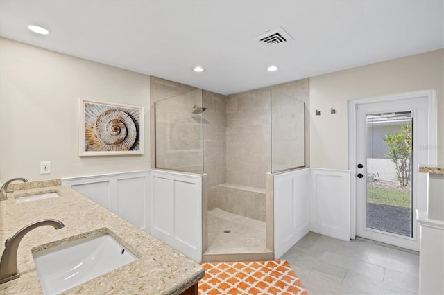 bathroom with a walk in shower, visible vents, and a sink