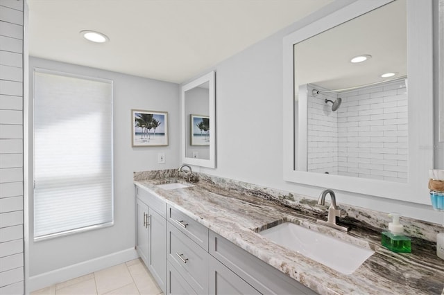 bathroom with tile patterned floors, a shower, double vanity, and a sink