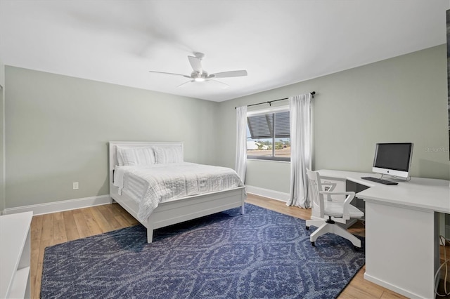 bedroom with a ceiling fan, light wood-style floors, and baseboards