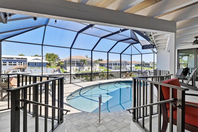 outdoor pool with a residential view, a lanai, a water view, and a patio area