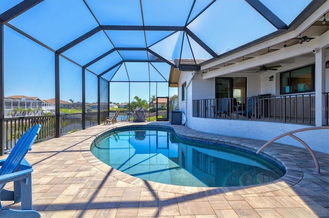 outdoor pool with a patio area, a lanai, and ceiling fan