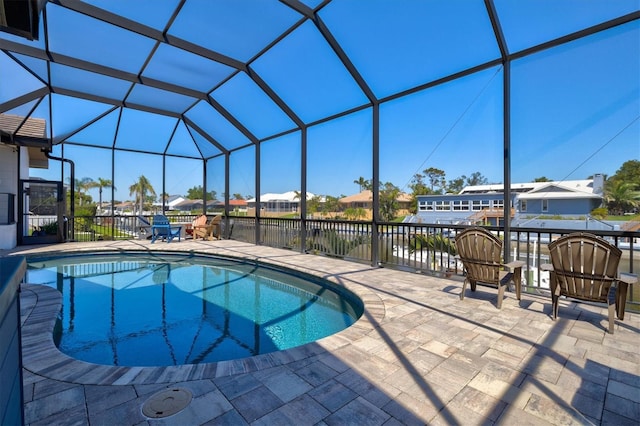 outdoor pool featuring glass enclosure and a patio