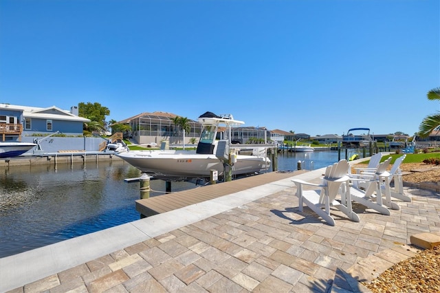 view of dock with a water view, a residential view, and boat lift