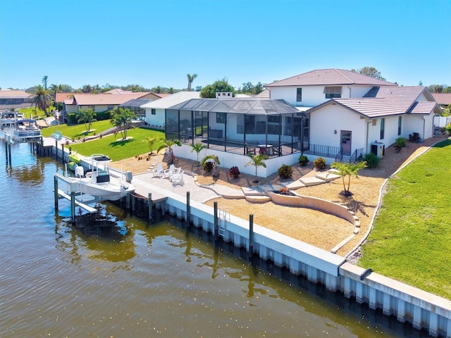 rear view of property with glass enclosure, a patio, a water view, boat lift, and a lawn