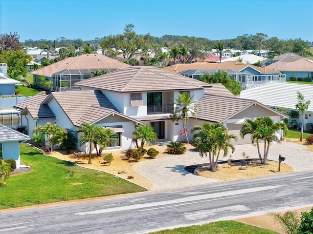 view of front of house featuring a tiled roof, decorative driveway, a residential view, and stucco siding