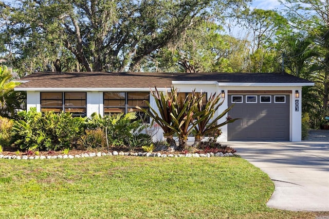 view of front of property with a garage, a front yard, driveway, and stucco siding