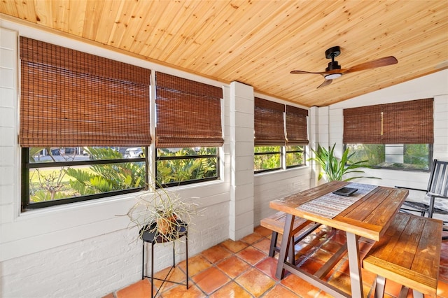 sunroom with lofted ceiling, wood ceiling, and ceiling fan