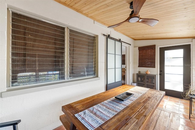 dining space with a barn door, wood ceiling, and ceiling fan