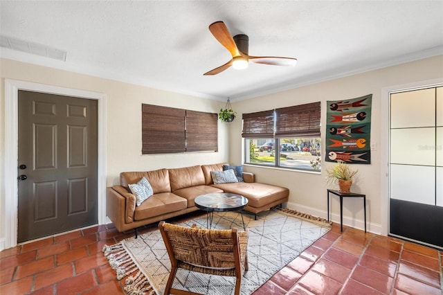 living room with crown molding, baseboards, visible vents, and ceiling fan