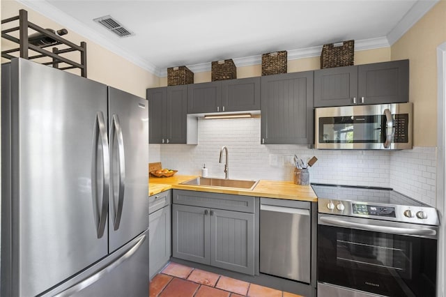 kitchen with visible vents, gray cabinetry, ornamental molding, appliances with stainless steel finishes, and a sink