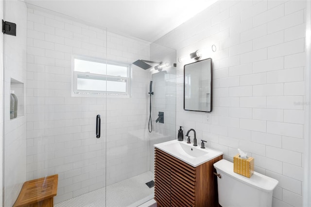 full bathroom featuring a shower stall, vanity, toilet, and tile walls