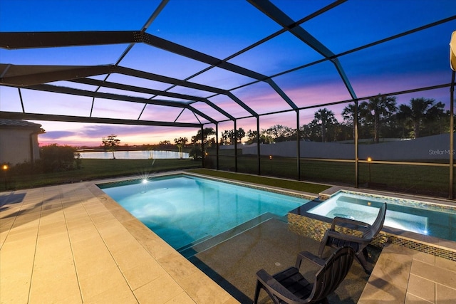 pool at dusk featuring a patio, a yard, a pool with connected hot tub, and a lanai