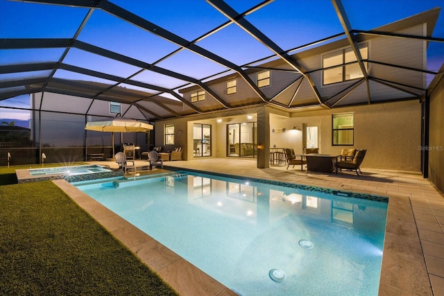 pool at dusk with a lanai, a patio area, and a pool with connected hot tub