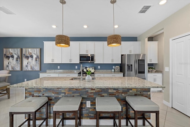 kitchen featuring white cabinets, visible vents, appliances with stainless steel finishes, and a sink