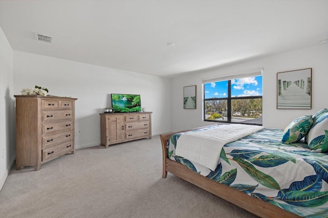 bedroom with visible vents, light colored carpet, and baseboards