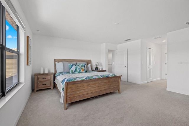 bedroom with baseboards, visible vents, and light carpet