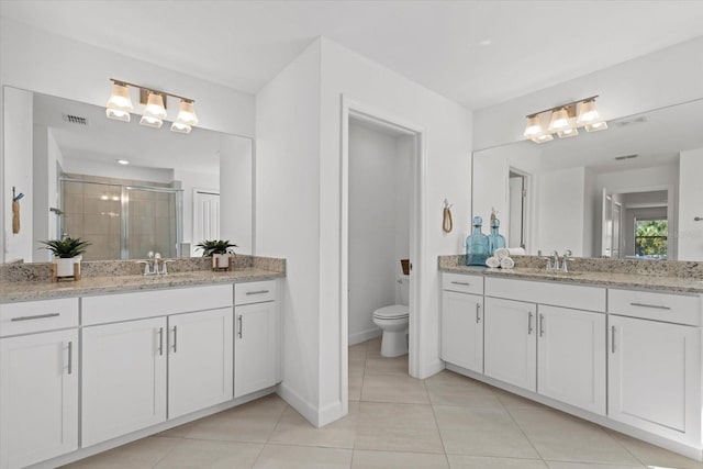 bathroom with visible vents, a sink, tile patterned flooring, a shower stall, and toilet