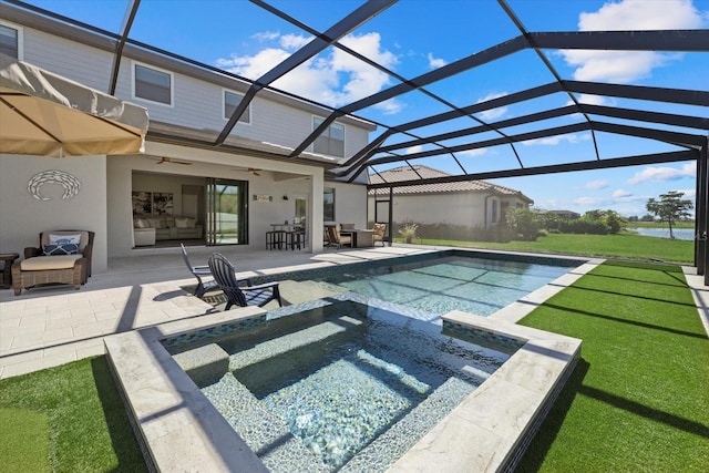 view of pool with glass enclosure, a ceiling fan, a yard, a pool with connected hot tub, and a patio area