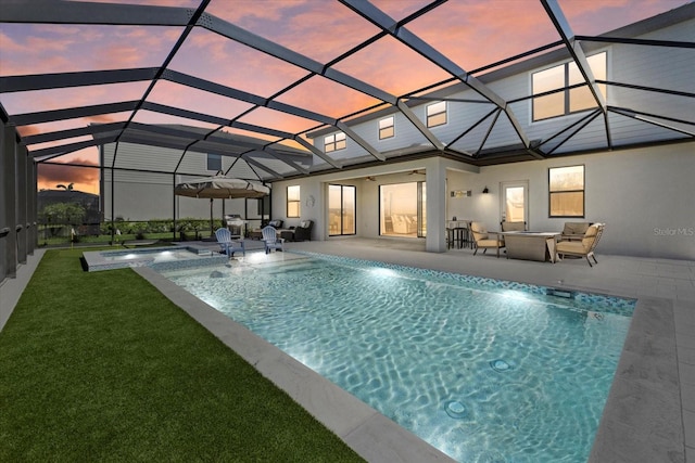 view of swimming pool featuring a yard, a pool with connected hot tub, a lanai, and a patio area